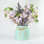 Florero con flor de cerezo y eucalipto artificial